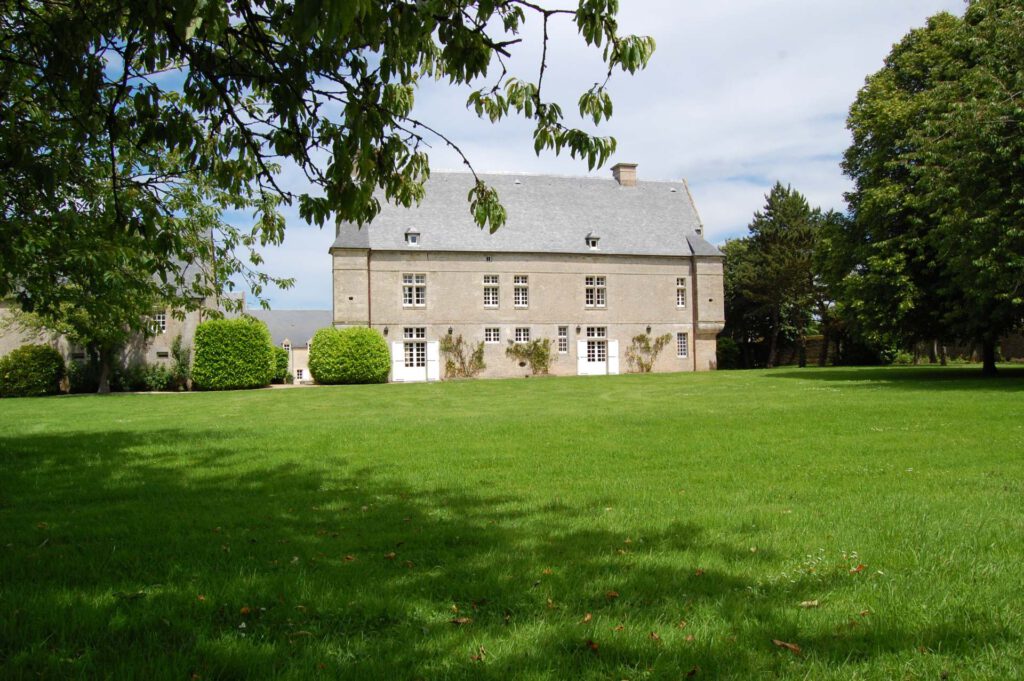 Stone House med have, beliggende i Asnelles, nær stranden, der tilbyder en fredelig og grøn omgivelse.