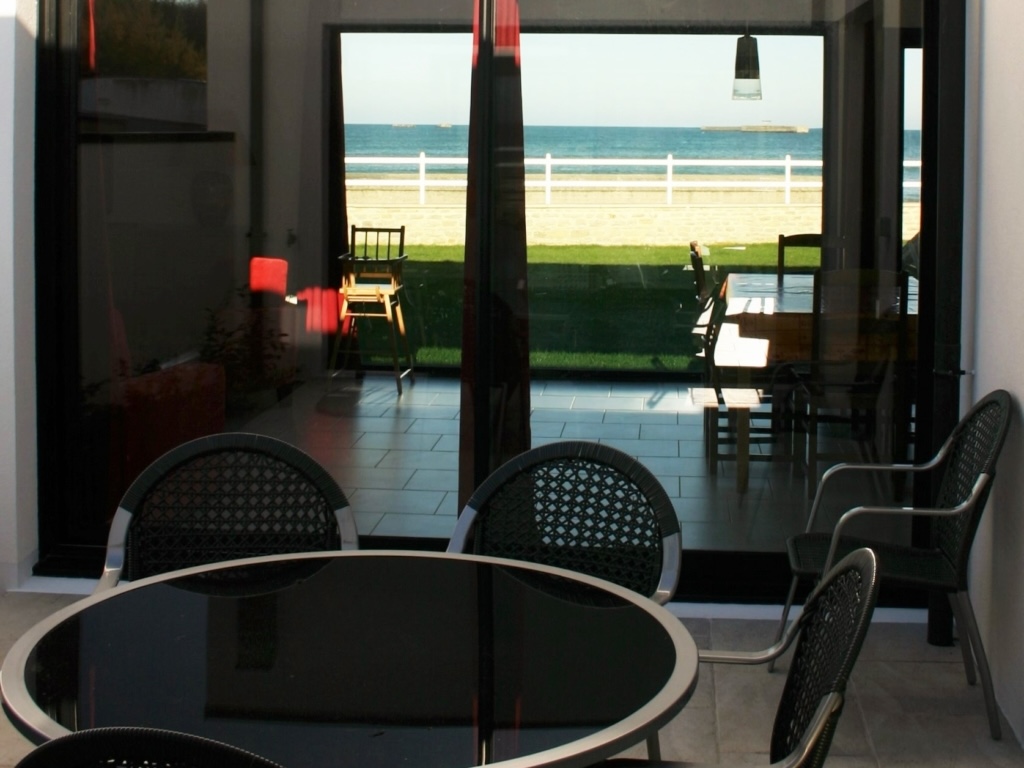Havudsigt fra et behageligt sommerhus i Asnelles med udendørs møbler og direkte adgang til stranden.
